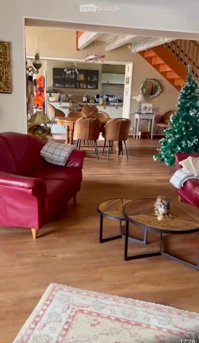 open plan living room and dining area, wooden floor, red leather sofa, coffee tables, dining table and chairs, Christmas tree, wooden staircase