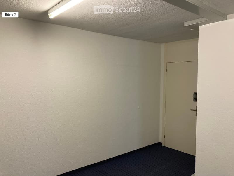 Empty room with white walls, ceiling, and floor, a door, and a light fixture