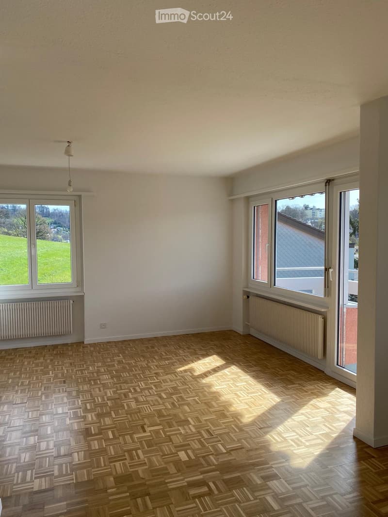 empty room, wooden parquet floor, white walls, large windows, balcony, view of the hills