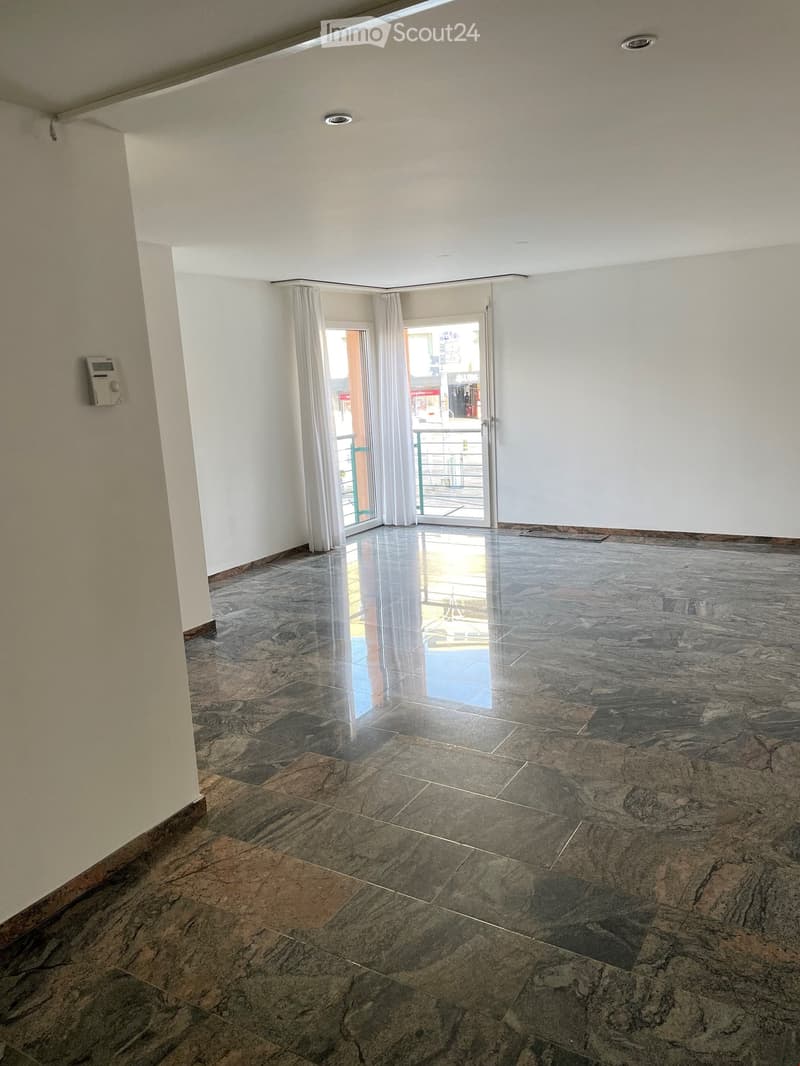 Empty room with marble floor, white walls, sliding glass door, balcony