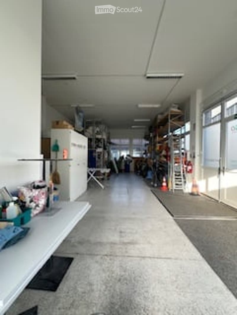 Empty room with white walls, white floor, shelves, tables, and various items
