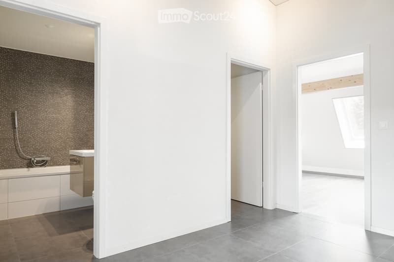 Bathroom. Modern bathroom with a bathtub, sink, and showerhead. The space features white walls, a tiled backsplash, and a large window allowing natural light to enter.