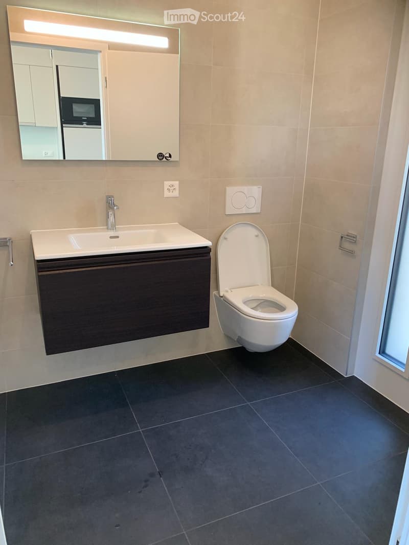 Bathroom with sink, toilet, mirror, and tiled floor