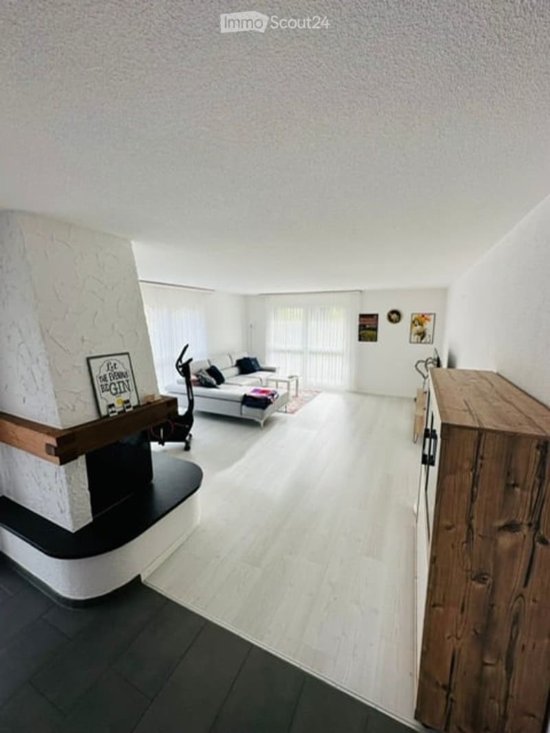 white walls, white floor, fireplace, couch, wooden cabinet, picture frames