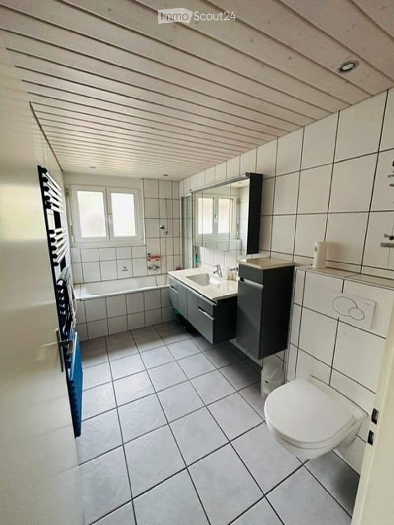 Bathroom with bathtub, sink, toilet, and tiled floor