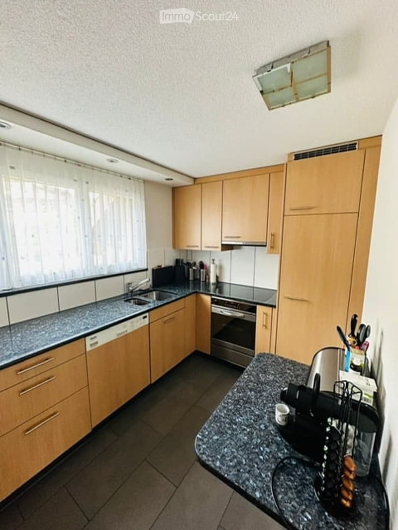 modern kitchen with wooden cabinets, granite countertops, dishwasher, washing machine, oven, sink, window with white curtains