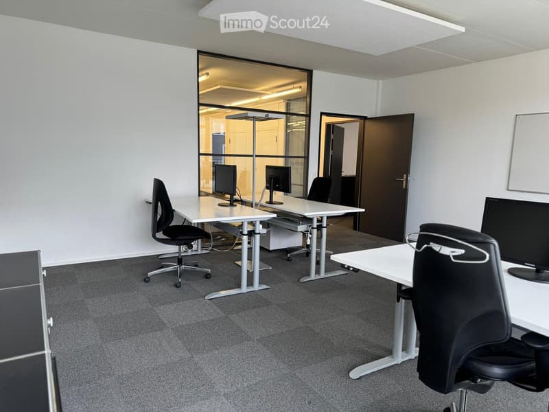 empty office room with desks, chairs, and monitors