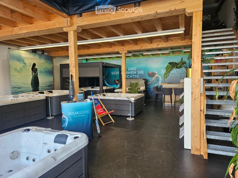 A showroom with multiple hot tubs, wooden beams, and a staircase.