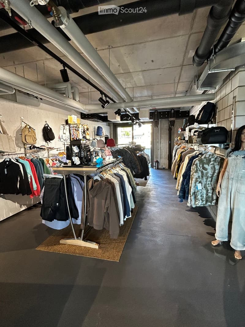 Clothing store with racks of clothes, a table with clothes, and a mannequin