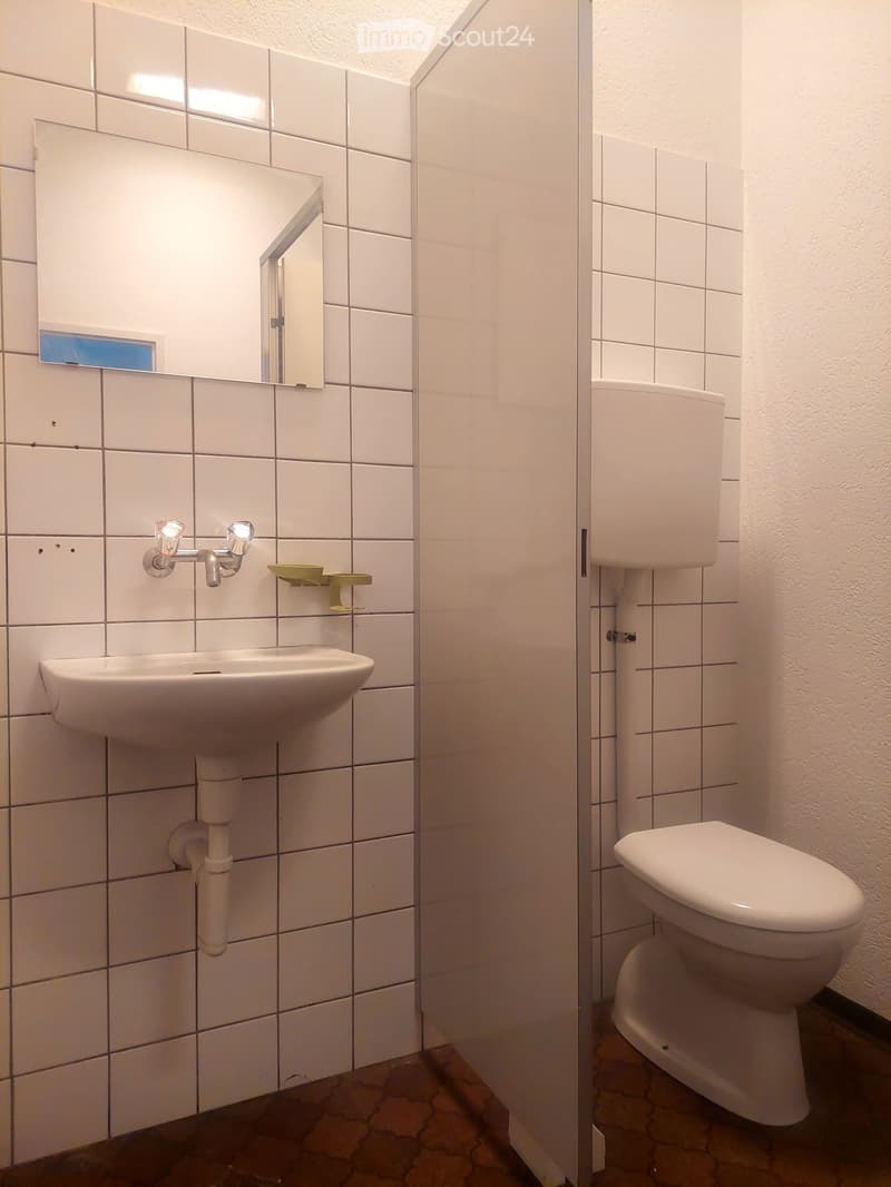 Bathroom with white tiles, sink, mirror, toilet, and shower curtain