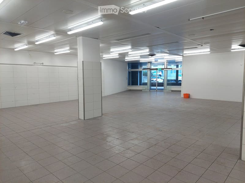 Empty room with tiled floor, white walls, and ceiling lights