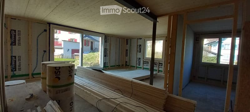 unfinished room, wooden beams, large windows, construction materials
