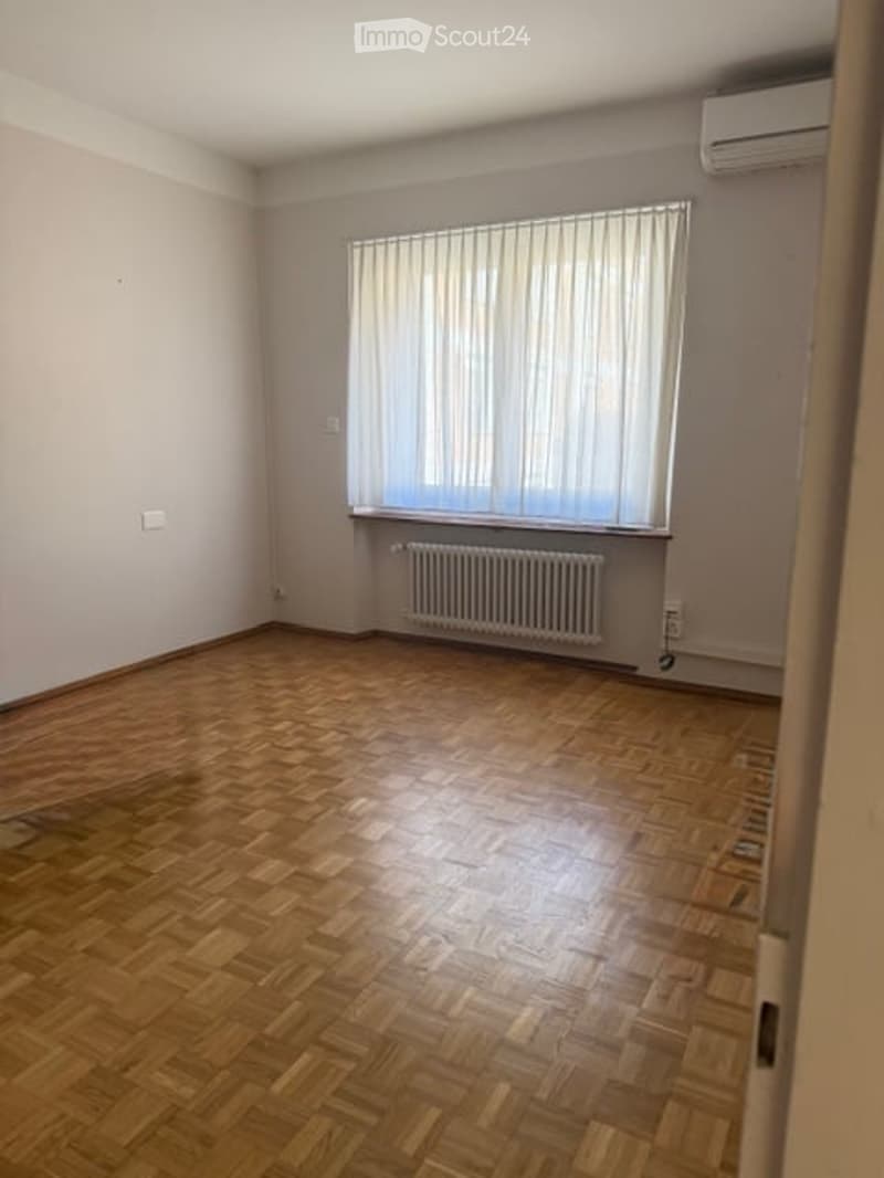 empty room, wooden floor, white walls, window with white curtains, white radiator, air conditioner