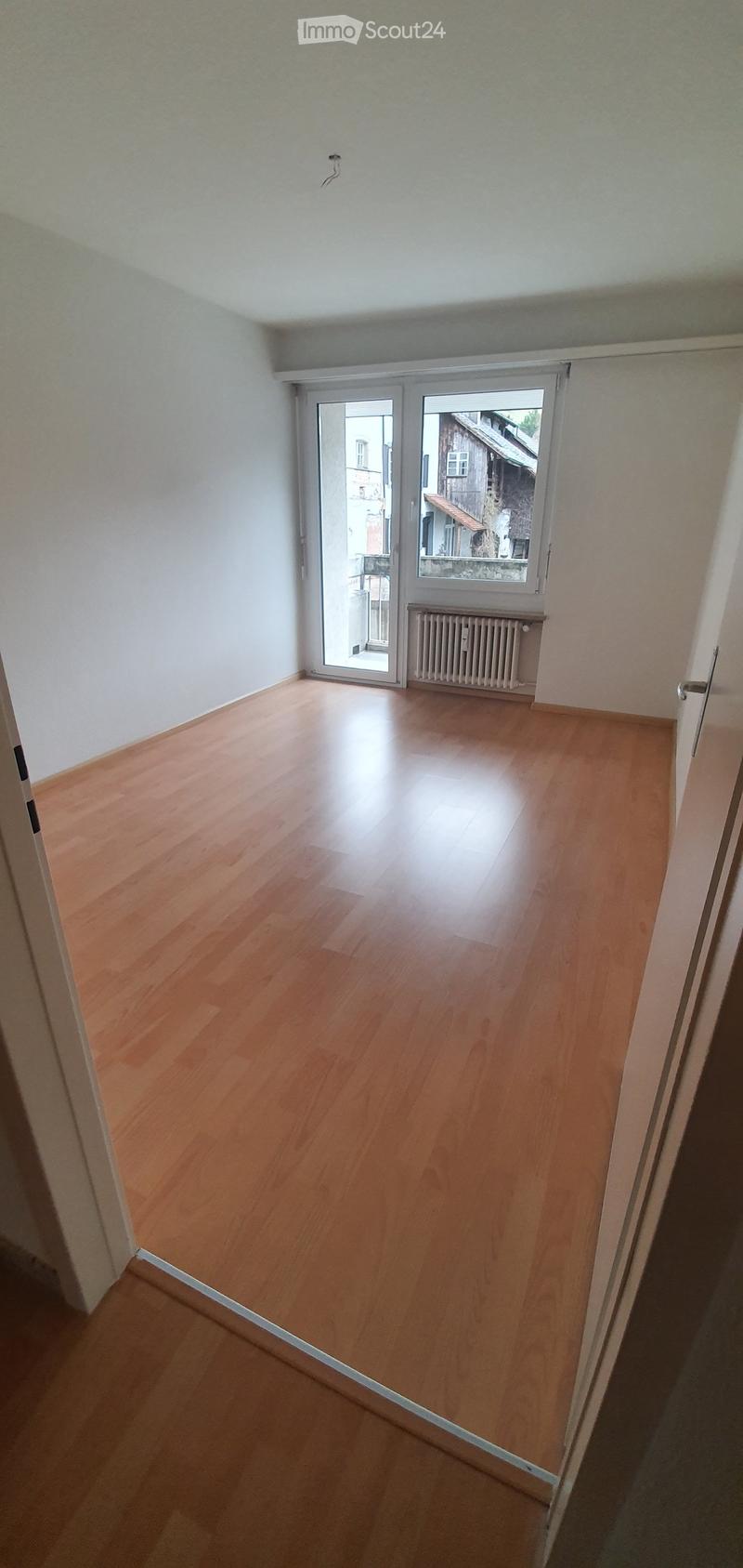 empty room, wooden floor, sliding glass door, white walls, white ceiling, radiator, view of the outside