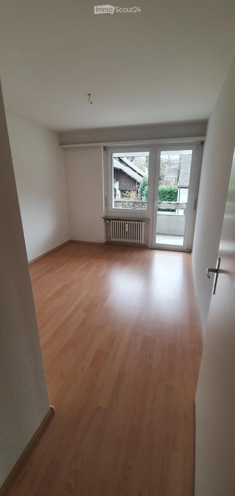 empty room, wooden floor, white walls, sliding glass door, balcony, radiator