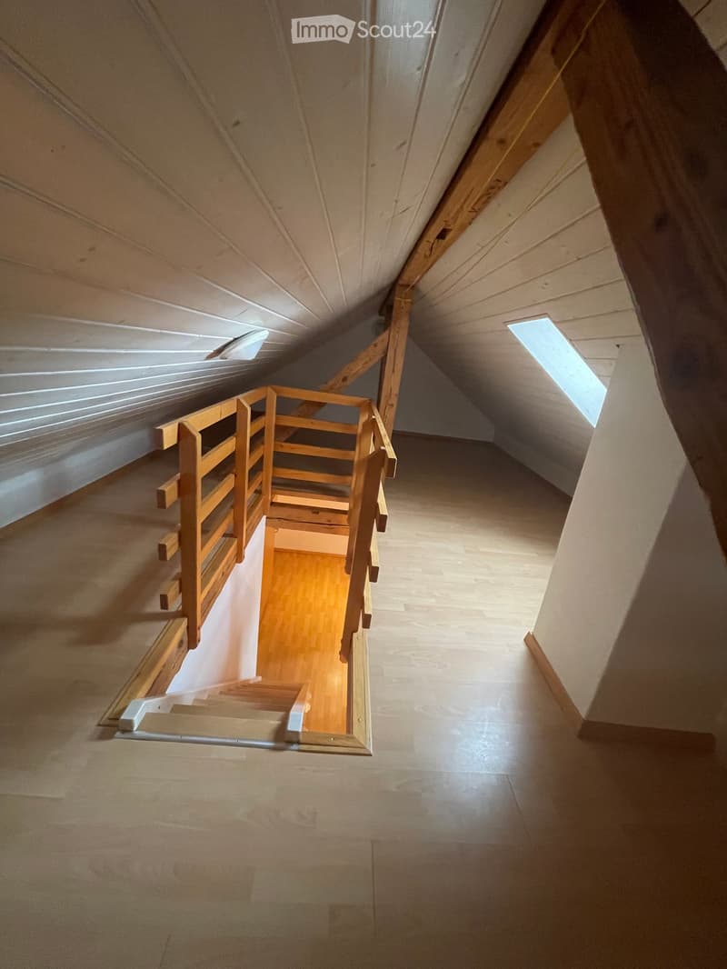 attic room with wooden stairs, wooden beams, wooden railing, wooden floor, white ceiling