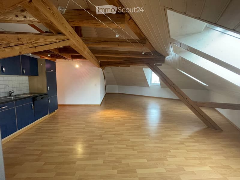 empty room, wooden floor, wooden beams, kitchen area with sink and cabinets, skylights