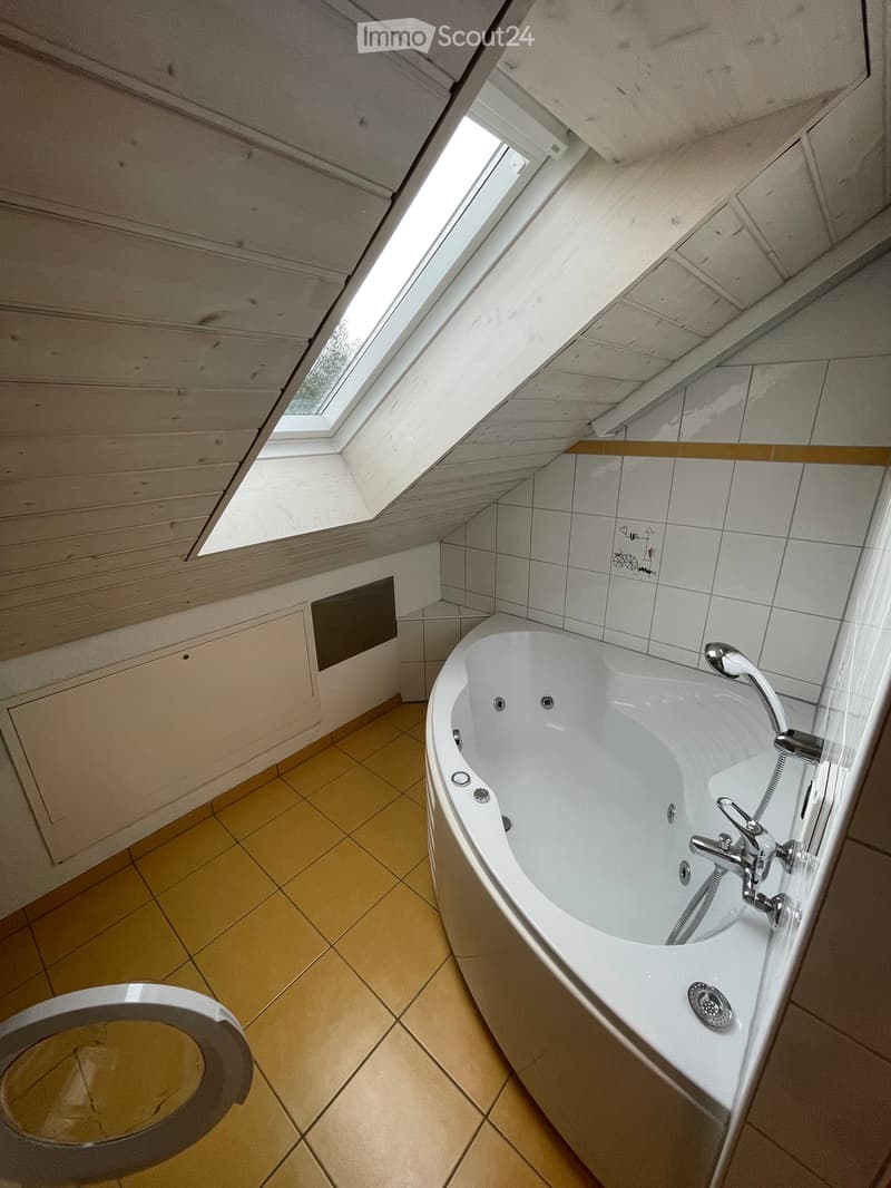 Bathroom with bathtub, toilet, and skylight