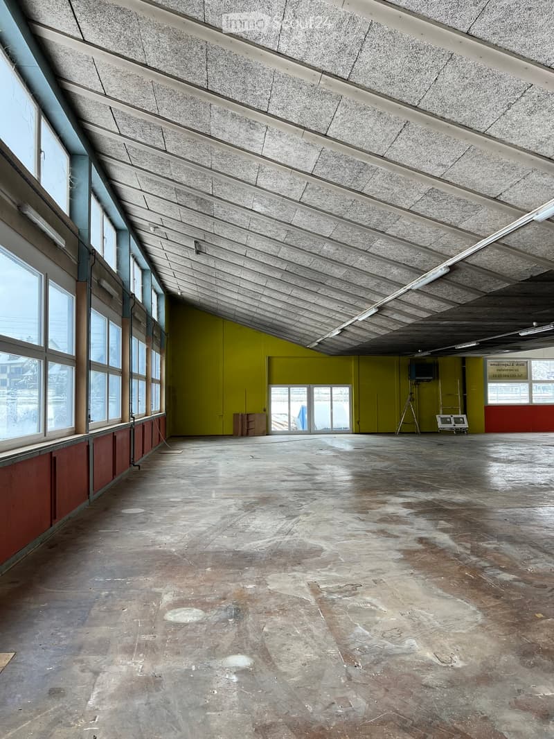 large empty room, high ceiling, large windows, yellow wall, wooden floor