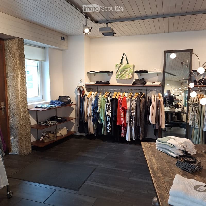 Clothing store with clothing racks, shelves, and a table with folded clothes