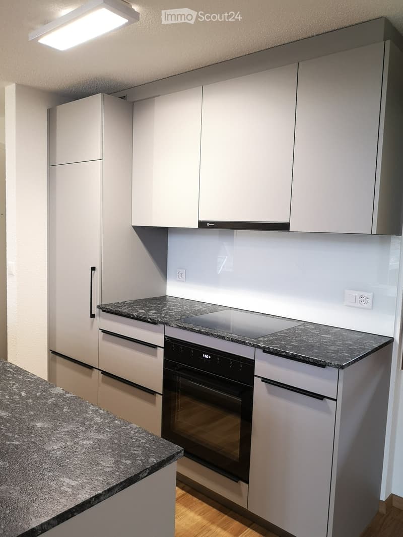 modern kitchen with white cabinets, granite countertops, built-in oven and stove, under cabinet lighting, power outlets