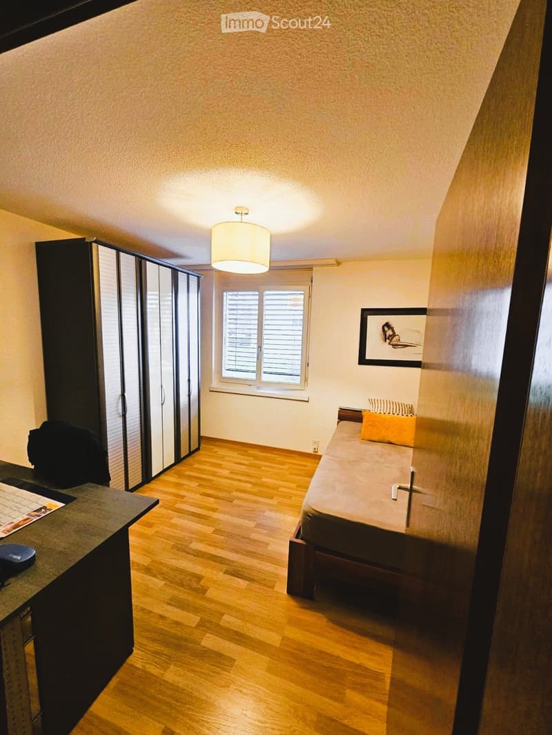 Bedroom with bed, wardrobe, desk, and window with blinds