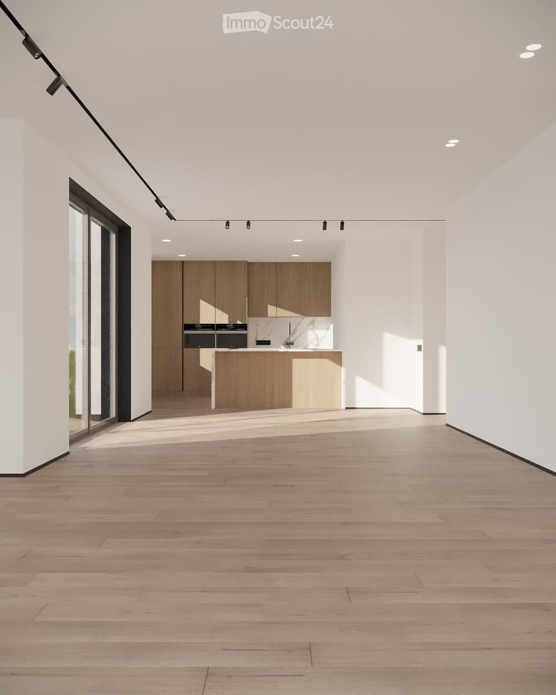 Empty room with light wooden flooring, white walls, and a modern kitchen area in the background featuring wooden cabinets and stainless steel appliances.