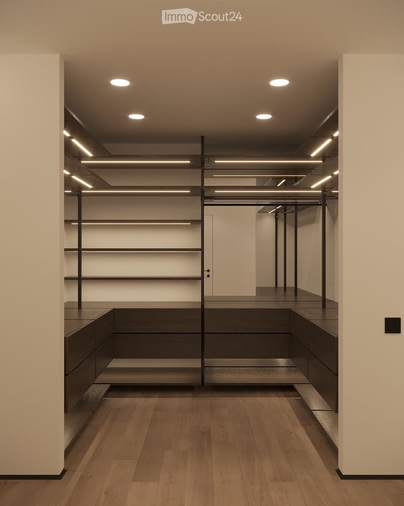 Modern, minimalist unfurnished room with wooden flooring, built-in shelving units, and recessed lighting. The space features a central island with built-in seating and storage, flanked by sleek, dark wooden cabinetry.