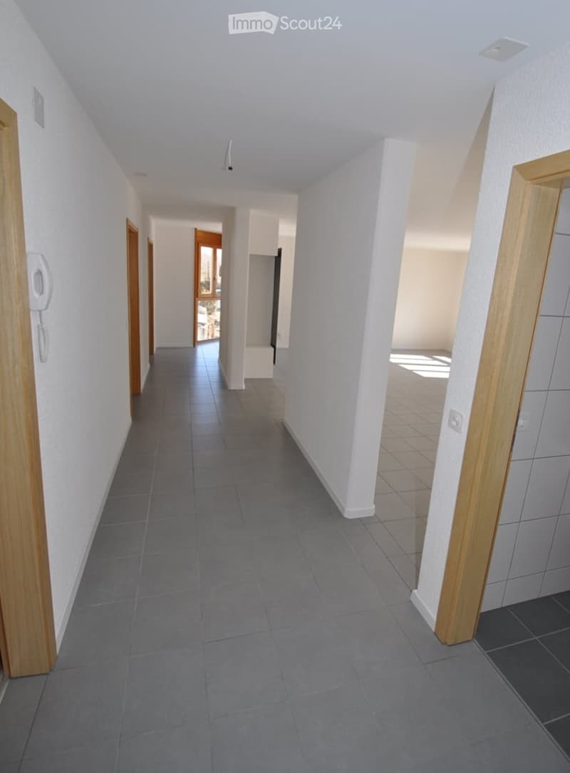 long hallway, tiled flooring, white walls, doors on both sides, phone on the wall, empty rooms at the end