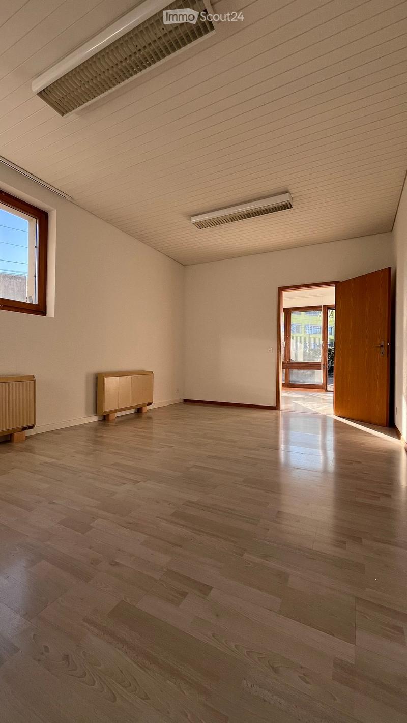 empty room, wooden floor, white walls, two wooden cabinets, two windows, open door
