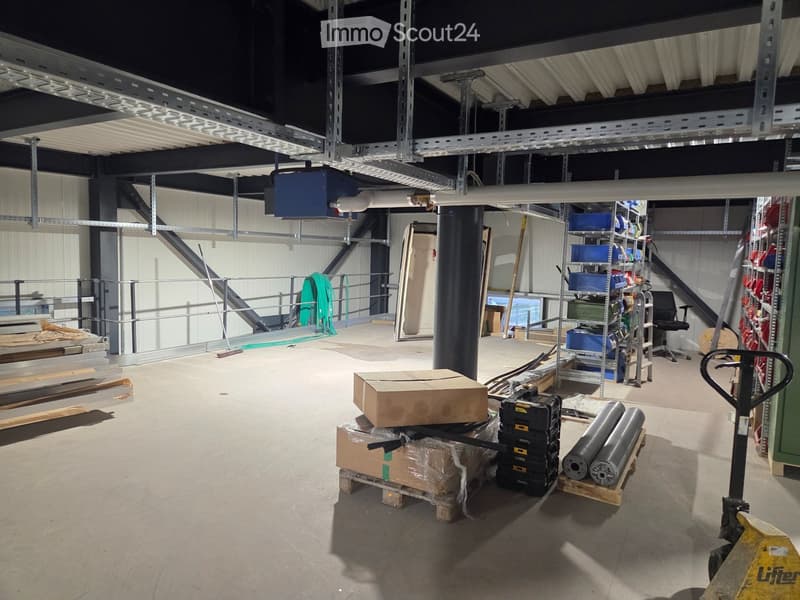 Empty warehouse with metal beams, storage boxes, and a forklift