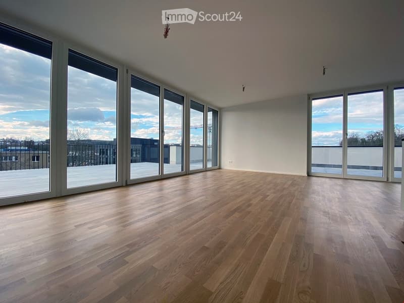 Open room with hardwood floors, glass sliding doors, balcony, wall socket, ceiling lamp