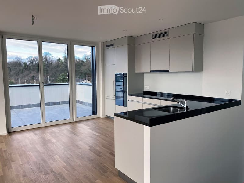 kitchen area, wooden floors, black countertops, white cabinets, large sliding glass doors, sink with faucet, oven, balcony