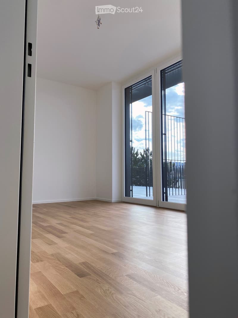 wooden floor, white walls, large windows, balcony with railings