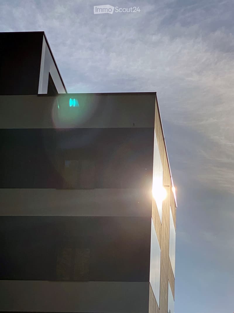 Modern building with glass windows and a sleek design, upper section with vertical stripes
