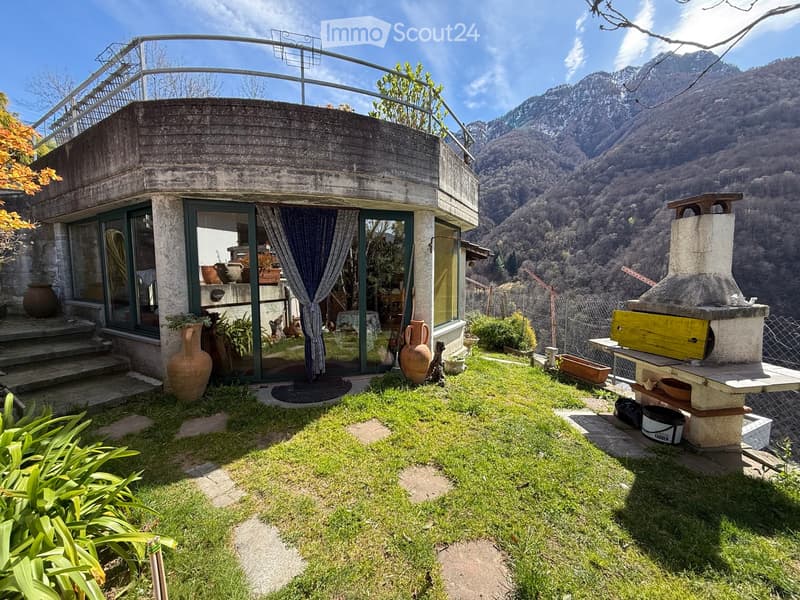Curved concrete house, large windows, balcony, garden, mountain view