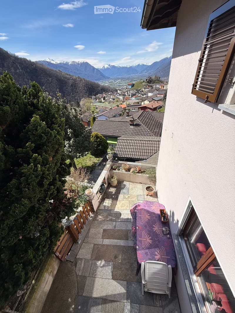 Terrace with table and chair, stone floor, plants, view of mountains