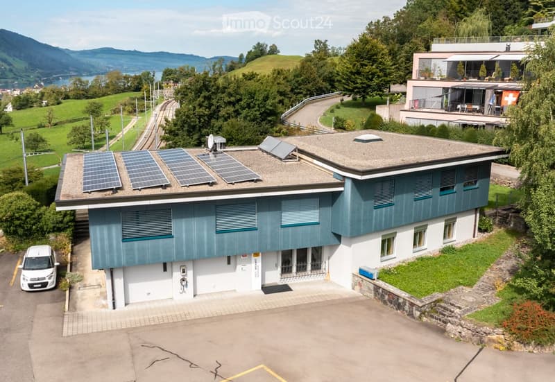 modern house, blue and white exterior, solar panels on the roof, garage, car parked in front