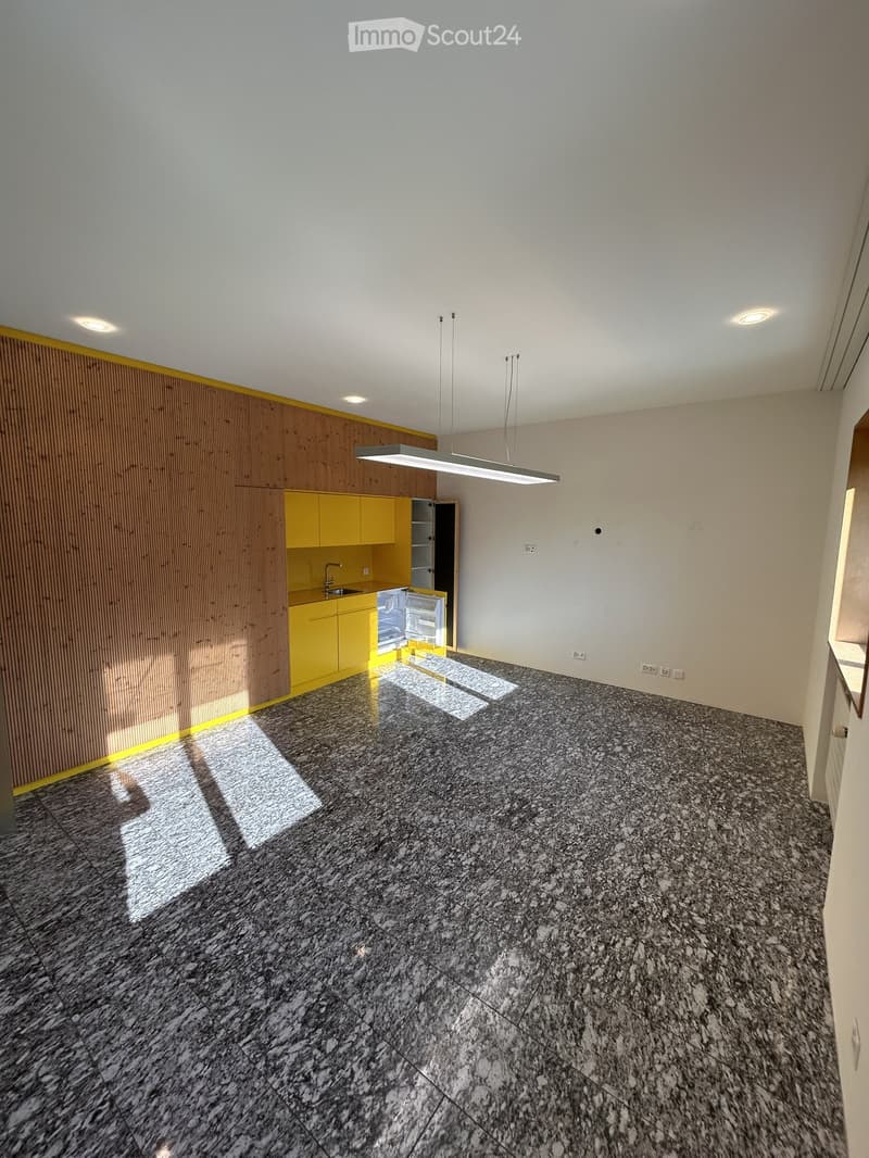 empty room, yellow cabinets, granite floor, white walls, ceiling lights, kitchen area
