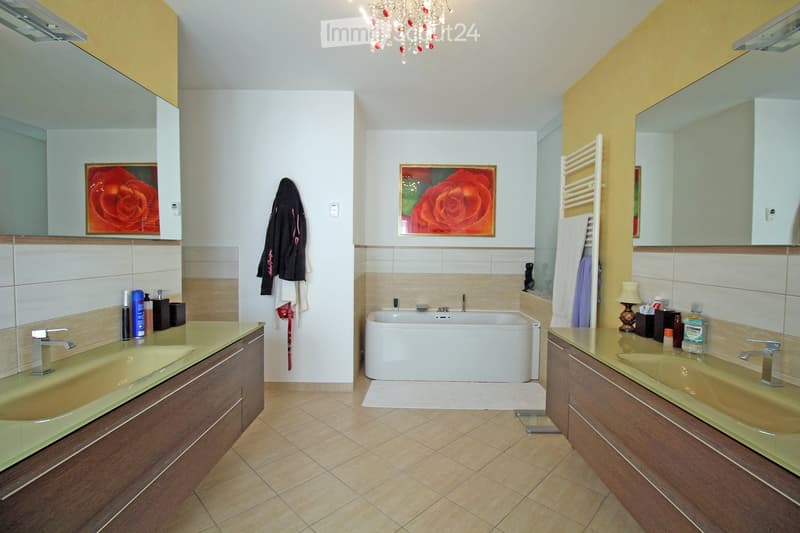 modern bathroom with two sinks, bathtub, large mirrors, and tiled floor
