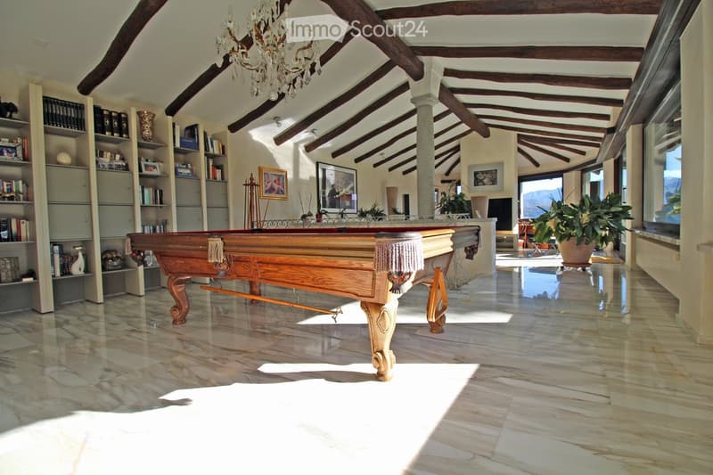 large room with marble floor, wooden pool table, wooden beams, chandelier, bookshelves, picture frames, plants