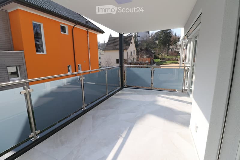 Balcony with glass railings, white tiled floor, modern design