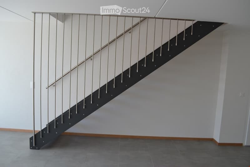 modern staircase with metal handrail, white walls, gray floor
