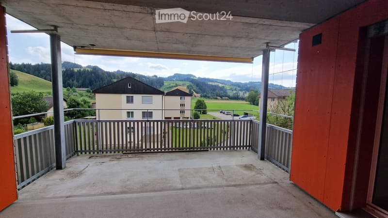 balcony with metal railing, open view to the outside, red walls, concrete floor