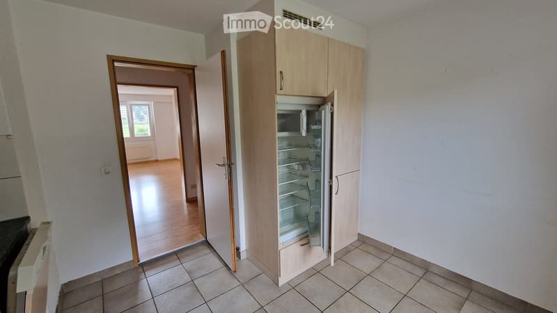 kitchen with open refrigerator, wooden floor, white walls, wooden door, window, white tiled floor