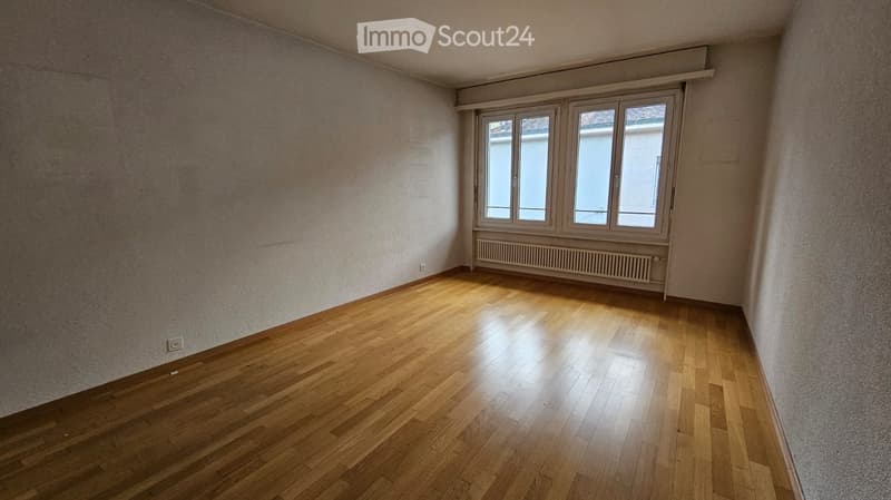 empty room, wooden floor, white walls, windows, radiator