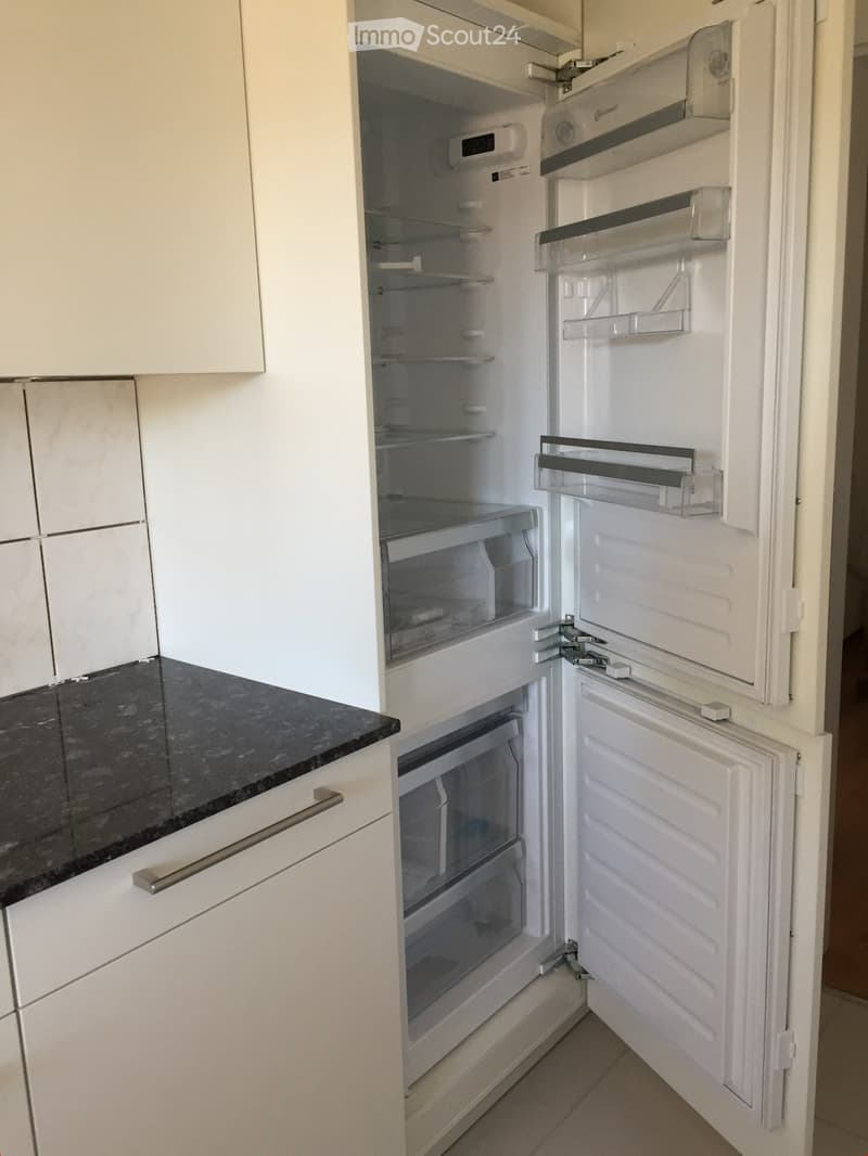 modern kitchen with white cabinets, black granite countertop, open refrigerator, dishwasher