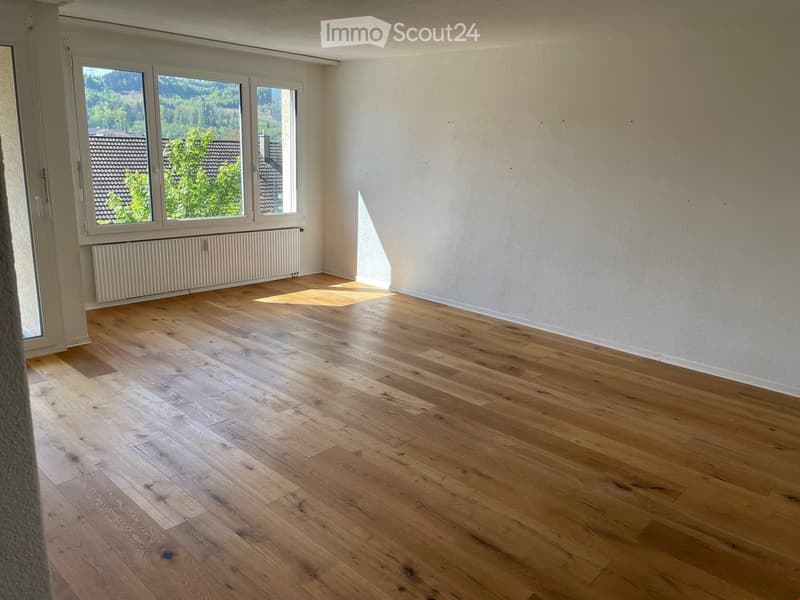 empty room, wooden floor, white walls, large windows, view of trees and houses