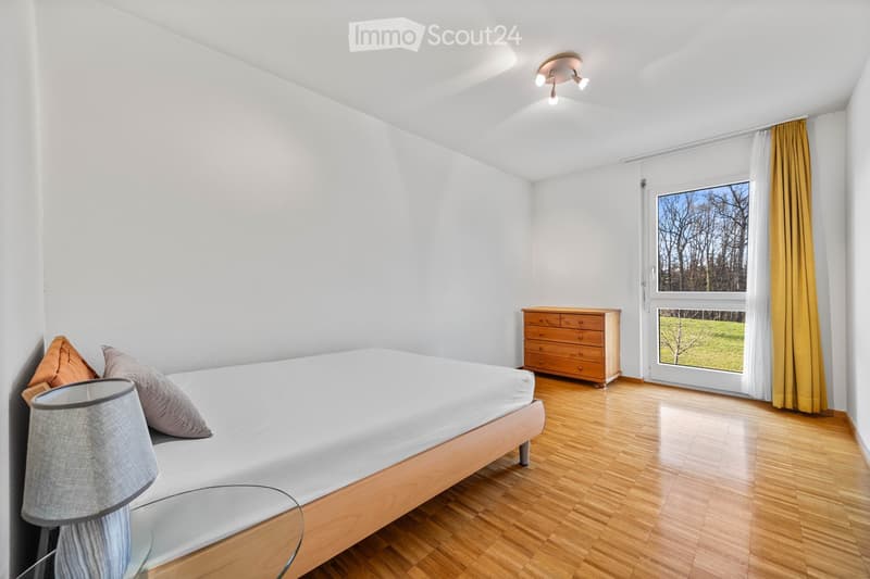 single bed, wooden floor, white walls, wooden cabinet, lamp, window with view