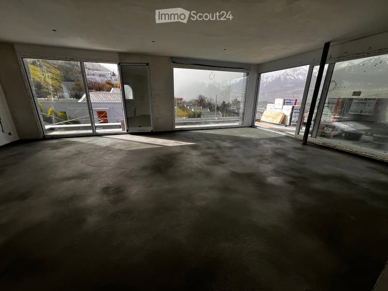 Empty room, concrete floor, large windows, mountain view